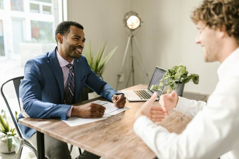 Men at a table with a computer having a meeting