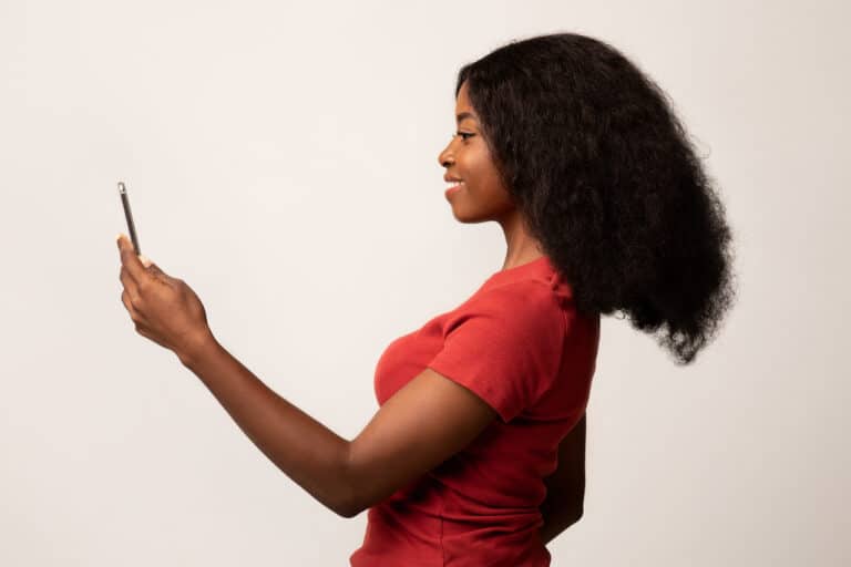 Example of passwordless authentication: woman using facial recognition to unlock phone