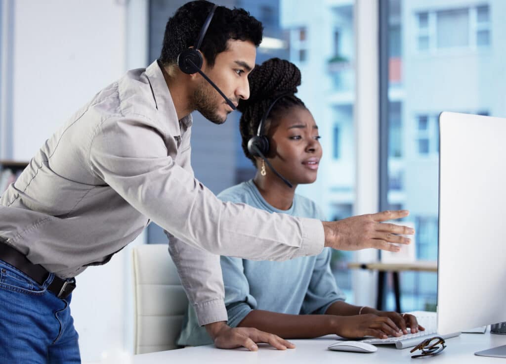 young man IT provider helping young woman at computer