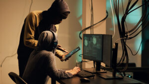 Hooded hackers at a computer